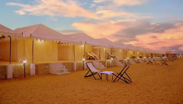 a beach chairs and a tent on a sandy beach
